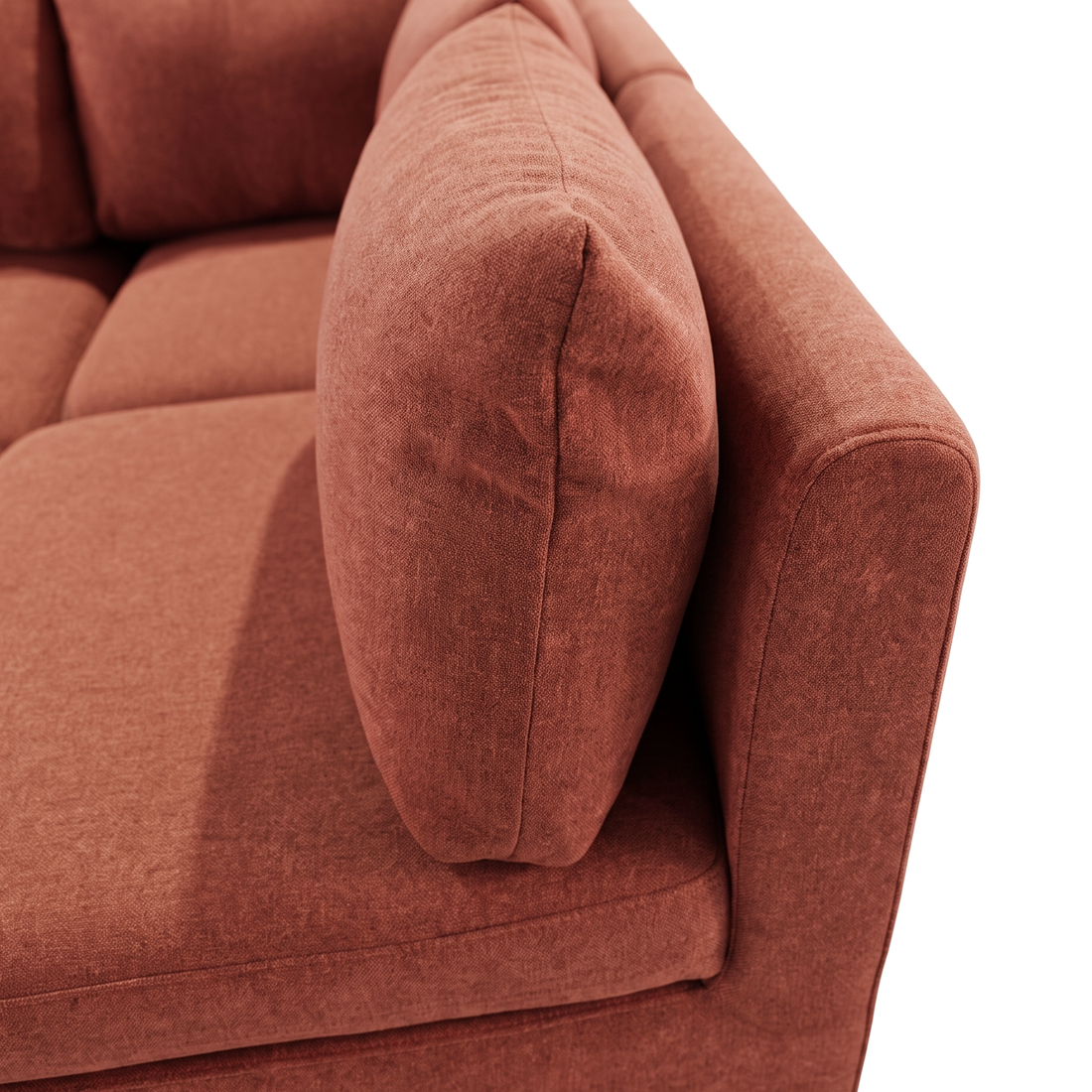 Close-up of rust terracotta sofa armrest and cushions