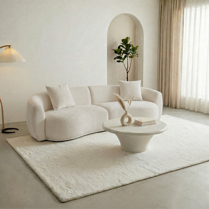 Lifestyle shot of curved sofa and coffee table in a modern living room