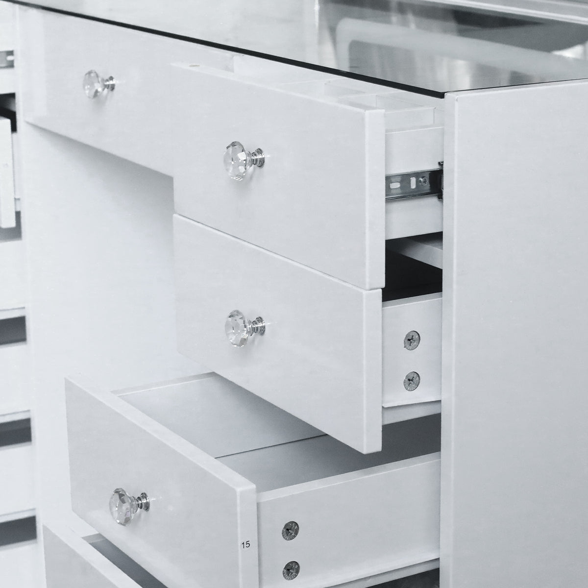 Partial view of white vanity chest of drawers in a room