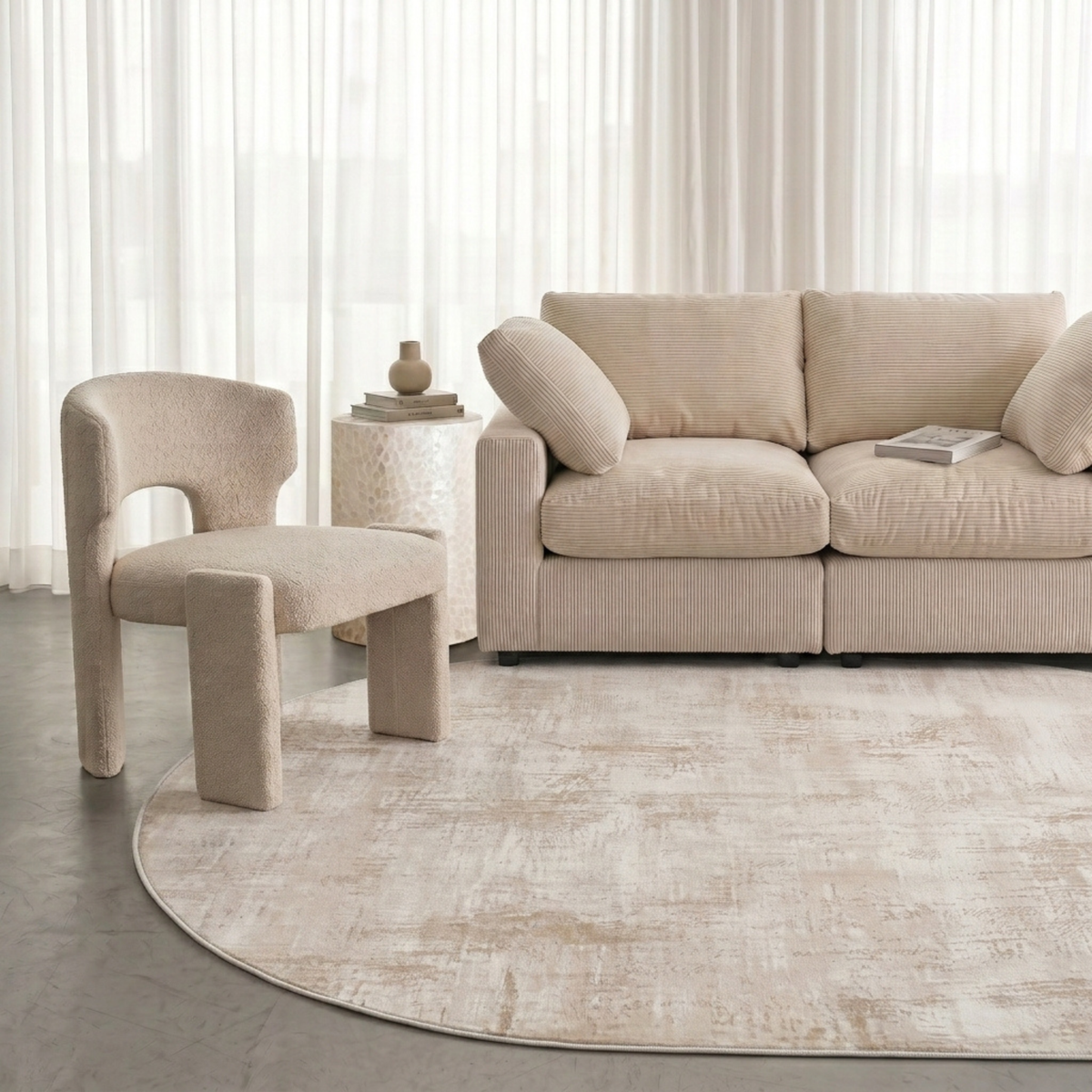 Cream-colored living room scene featuring a rug, sofa, chair, and side table
