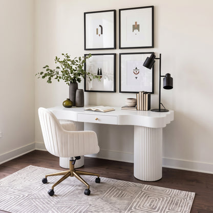 White desk with matching chair styled in a modern home office with decor and wall art