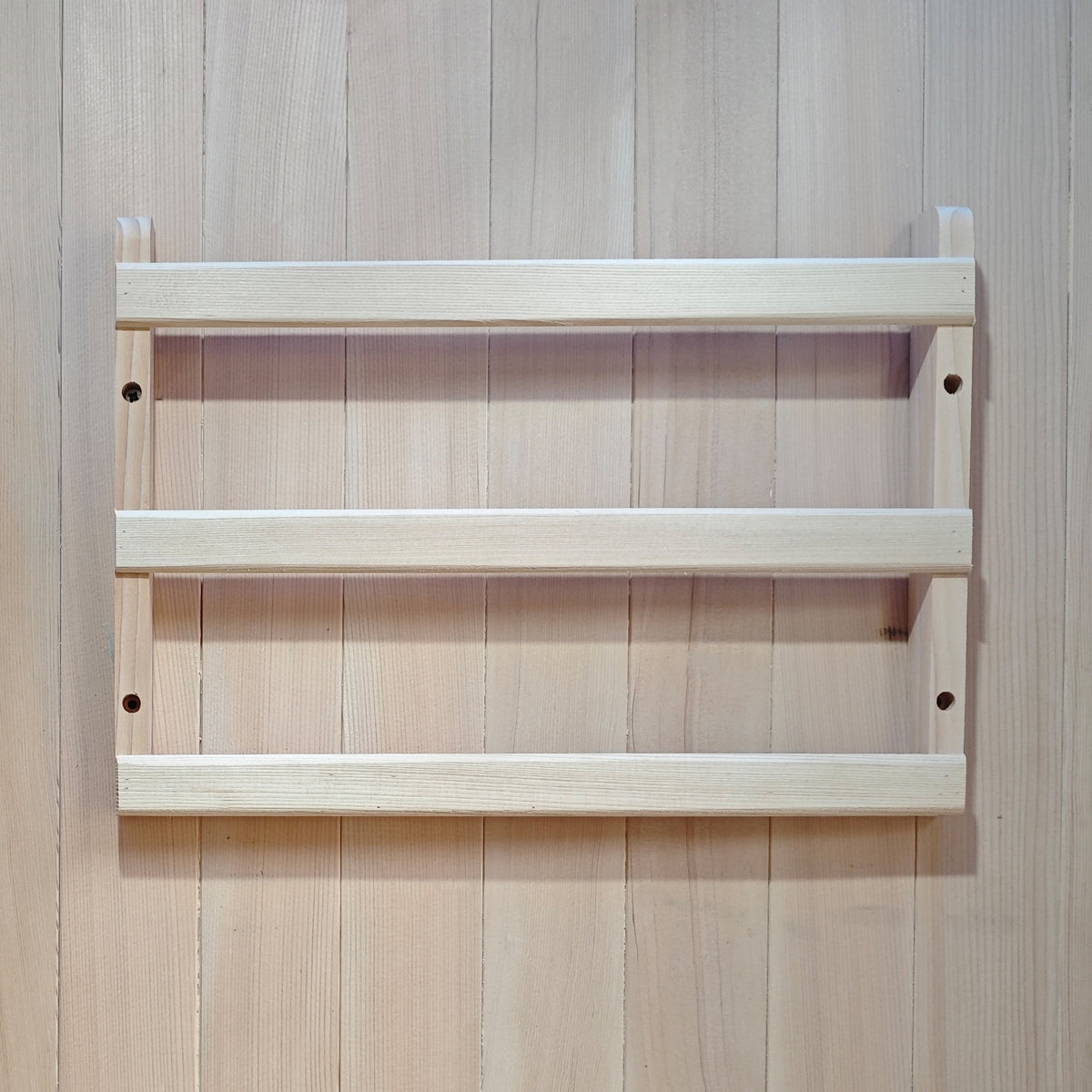 Small wooden wall-mounted rack on a wood-paneled wall.