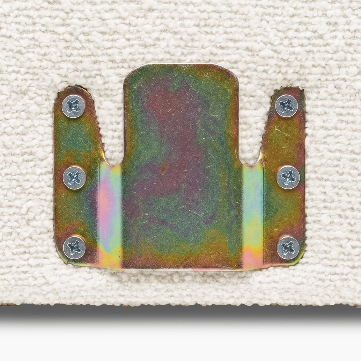 Close-up of metal bracket mounted on off-white fabric surface