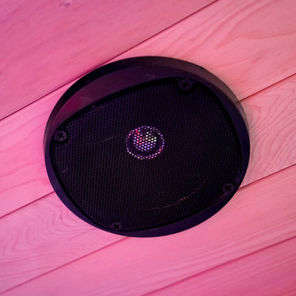 Round speaker mounted on a wood-paneled ceiling