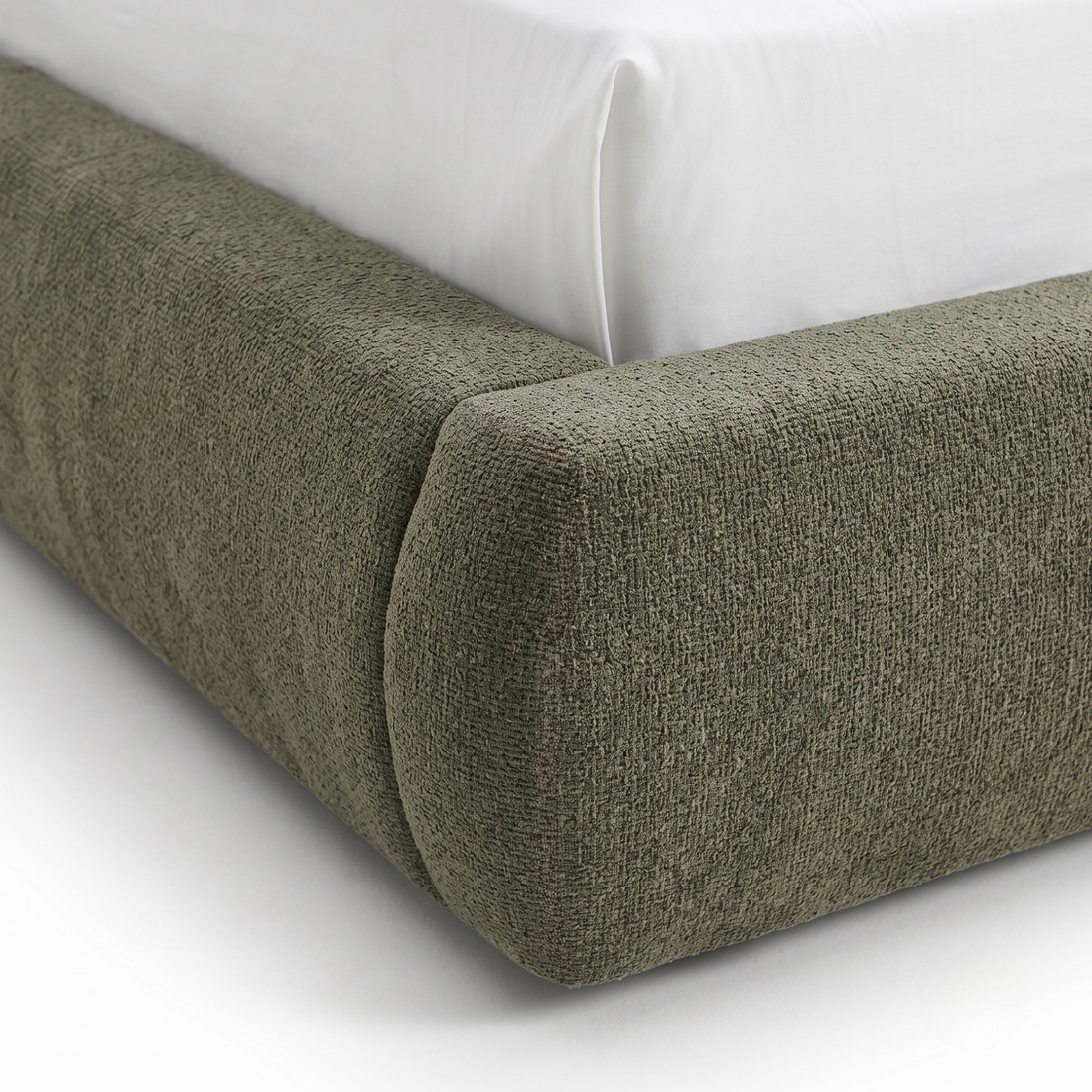 Close-up of upholstered bed frame corner on white background