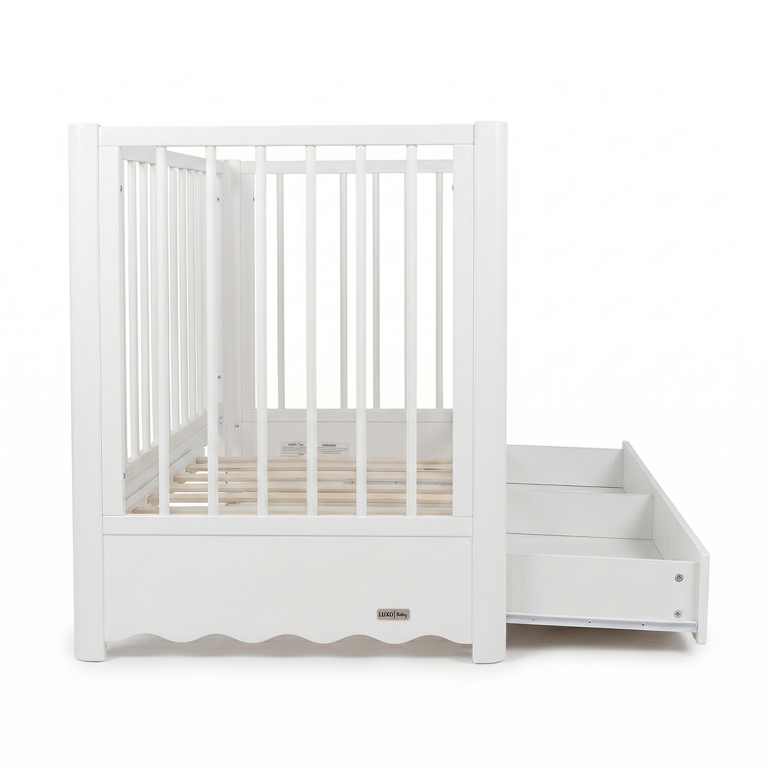 Front view of white baby crib with slatted sides and pull-out storage drawer on white background