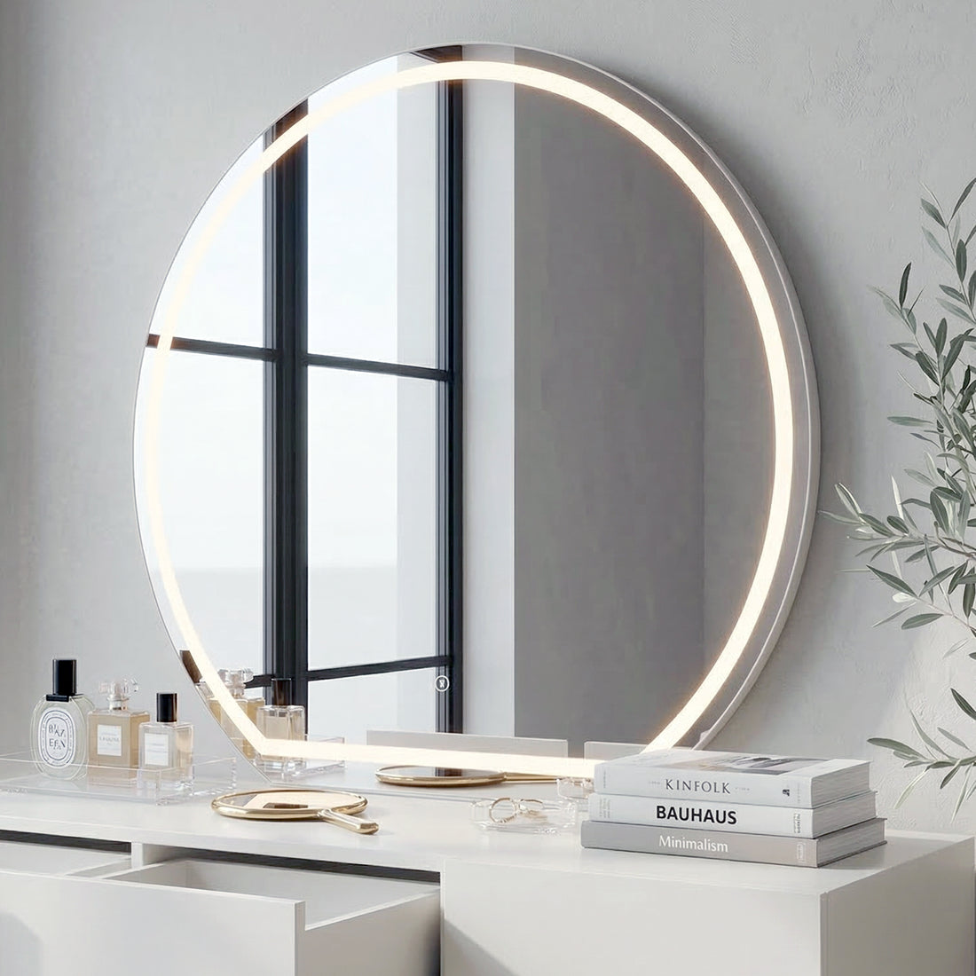 Round LED mirror mounted above white vanity table with decorative items in a modern room