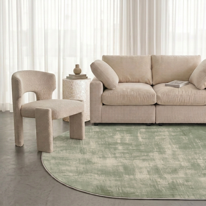 Modern living room with a green patterned rug, sofa, and accent chair