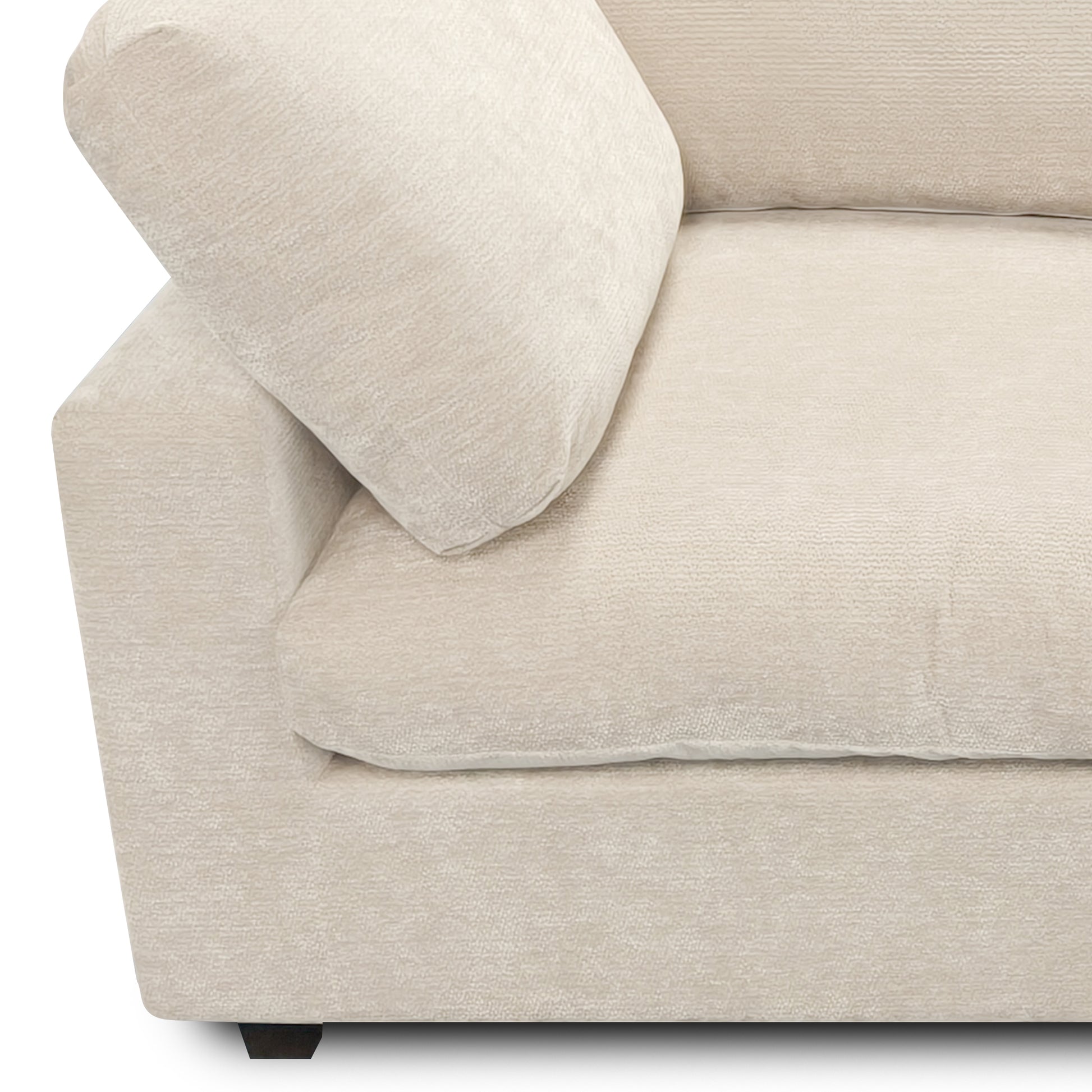 Partial view of beige upholstered sofa armrest and cushions on white background