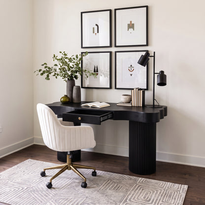 Modern black desk and white chair styled in a bright home office with art and decor