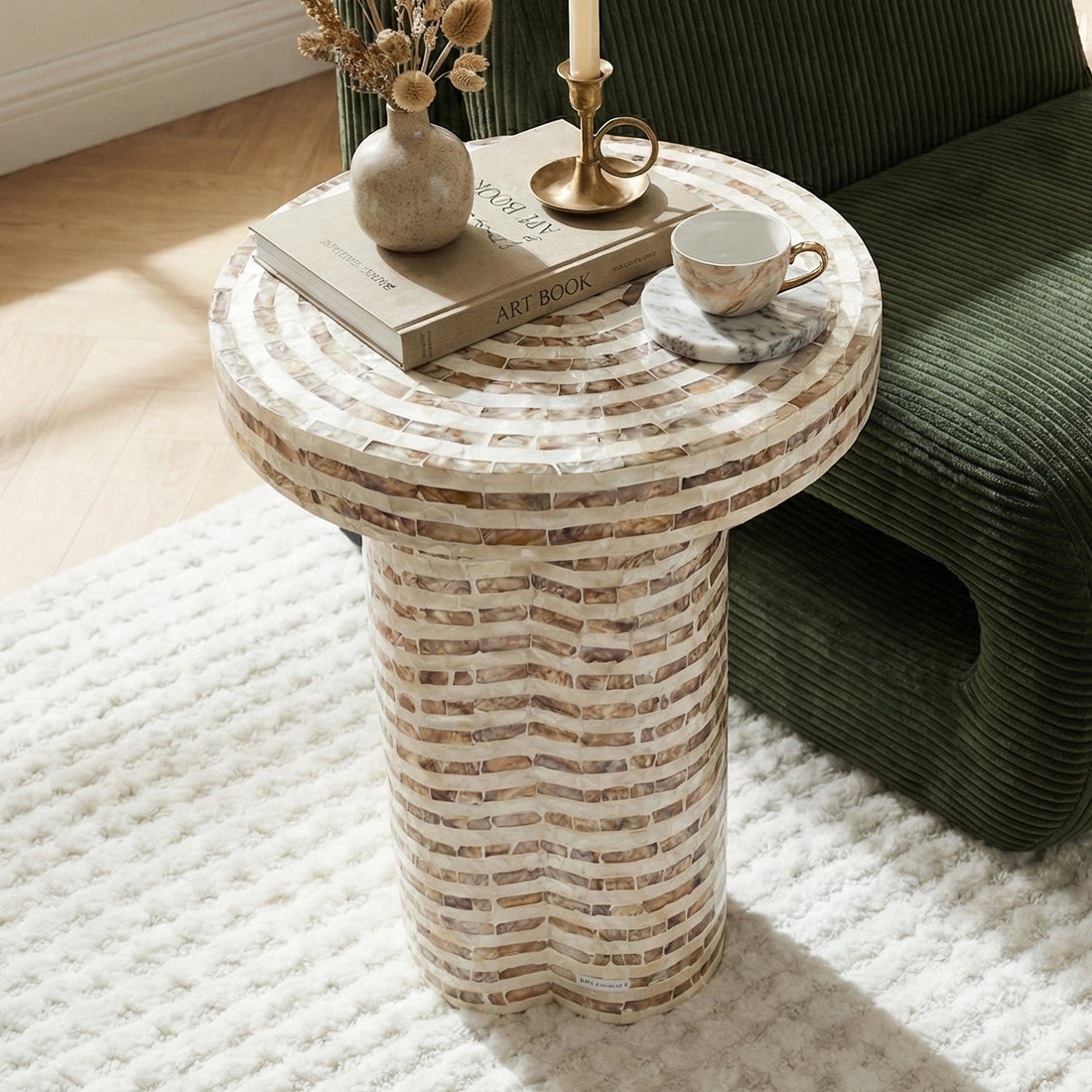 Round mosaic side table styled with decor in a sunlit room