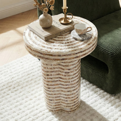 Round mosaic side table styled with decor in a sunlit room