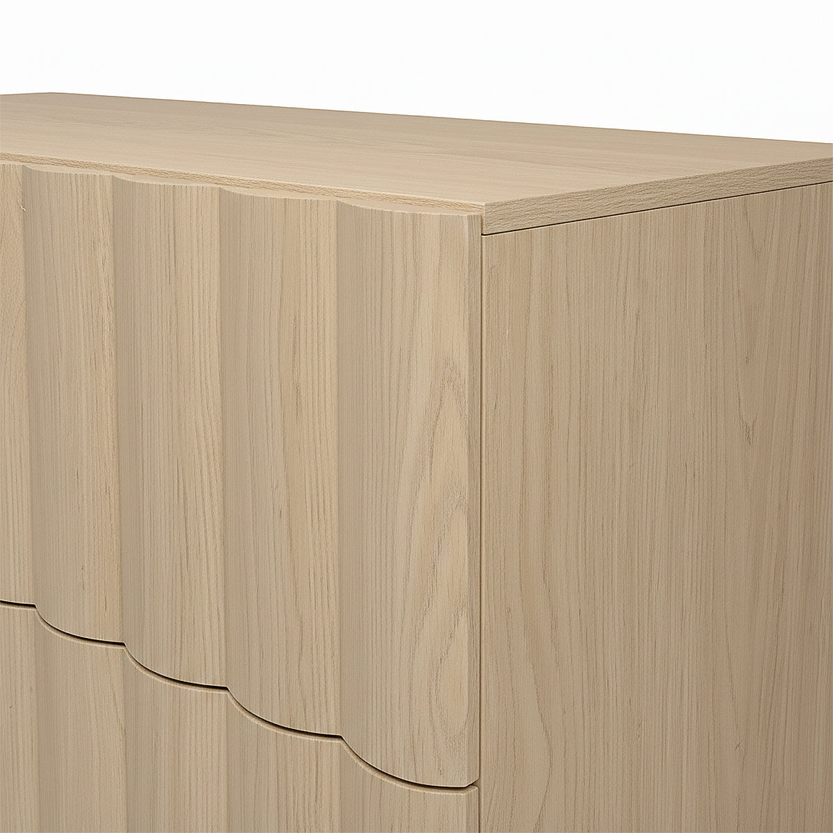 Close-up of the top corner of a light wood dresser on white background