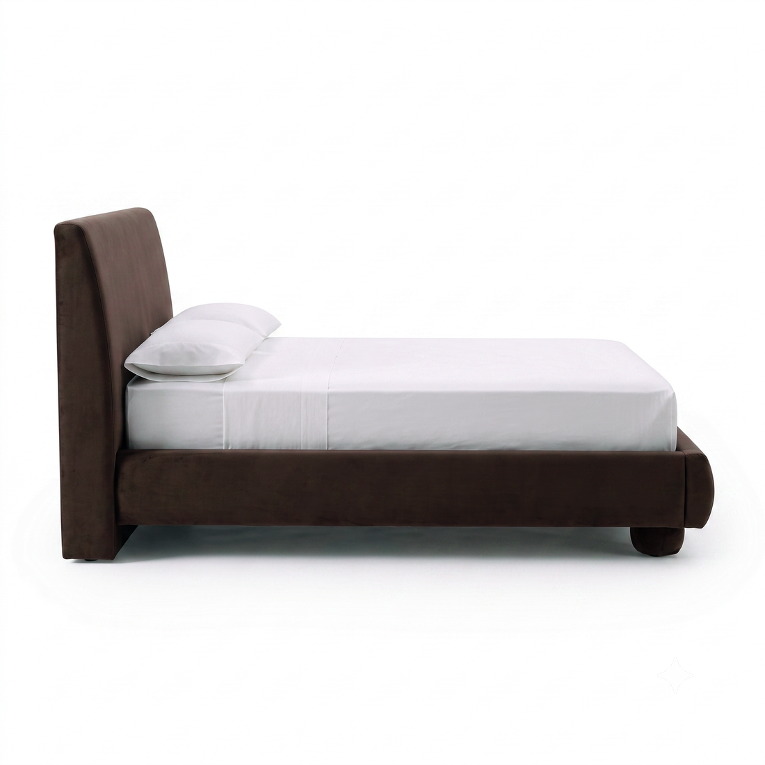 Side view of a dark brown upholstered bed with white bedding on white background