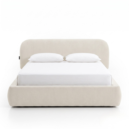 Modern upholstered bed with pillows on a white background