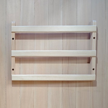 Light wood two-shelf wall rack mounted on a wood-paneled wall
