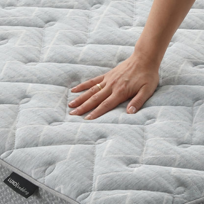 Close-up of mattress surface with a hand pressing down