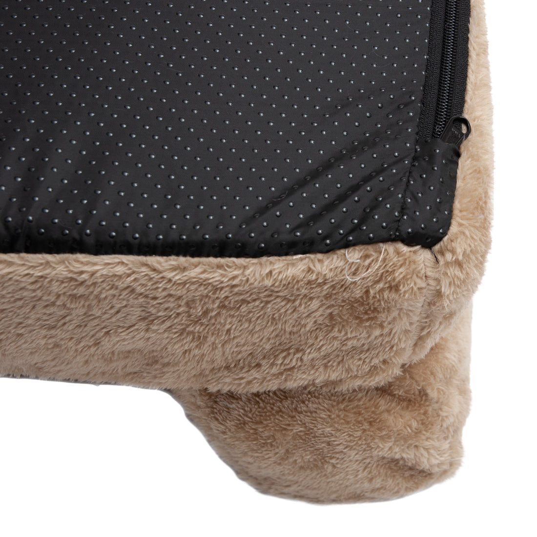 Corner close-up of beige plush fabric with black dotted fabric and zipper detail