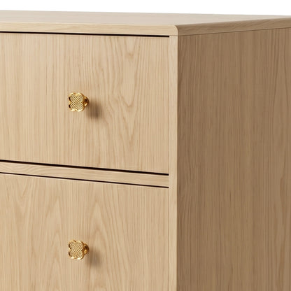 Close-up of upper drawers of wooden dresser showing gold quatrefoil knobs on white background