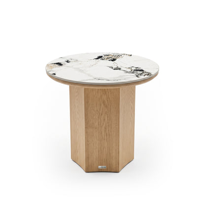 Round accent table with white marble top and faceted light wood base on white background