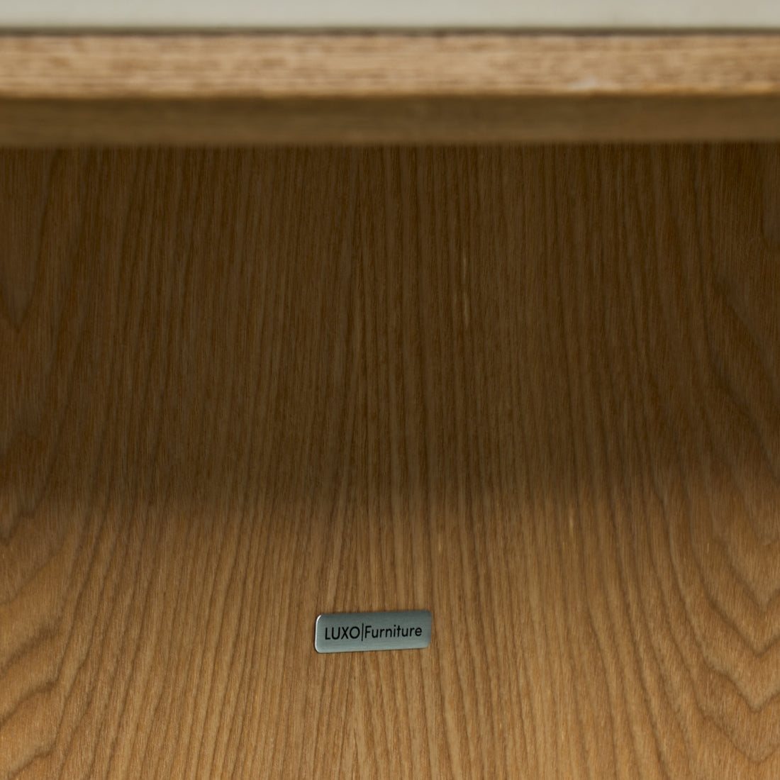 Close-up of wooden furniture surface with a LUXO Furniture label