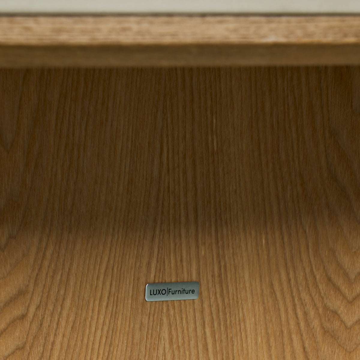 Close-up of wooden furniture surface with a LUXO Furniture label