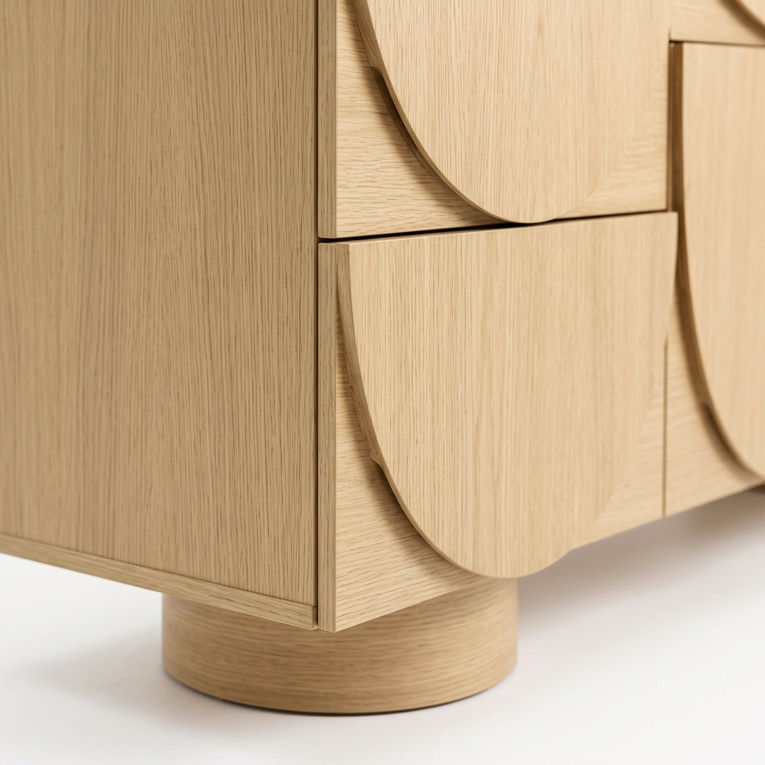 Close-up of the lower corner and drawer fronts of a wooden cabinet