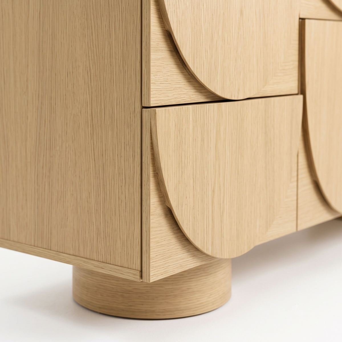 Close-up of the lower corner and drawer fronts of a wooden cabinet