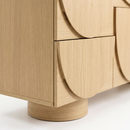 Close-up of the lower corner and drawer fronts of a wooden cabinet