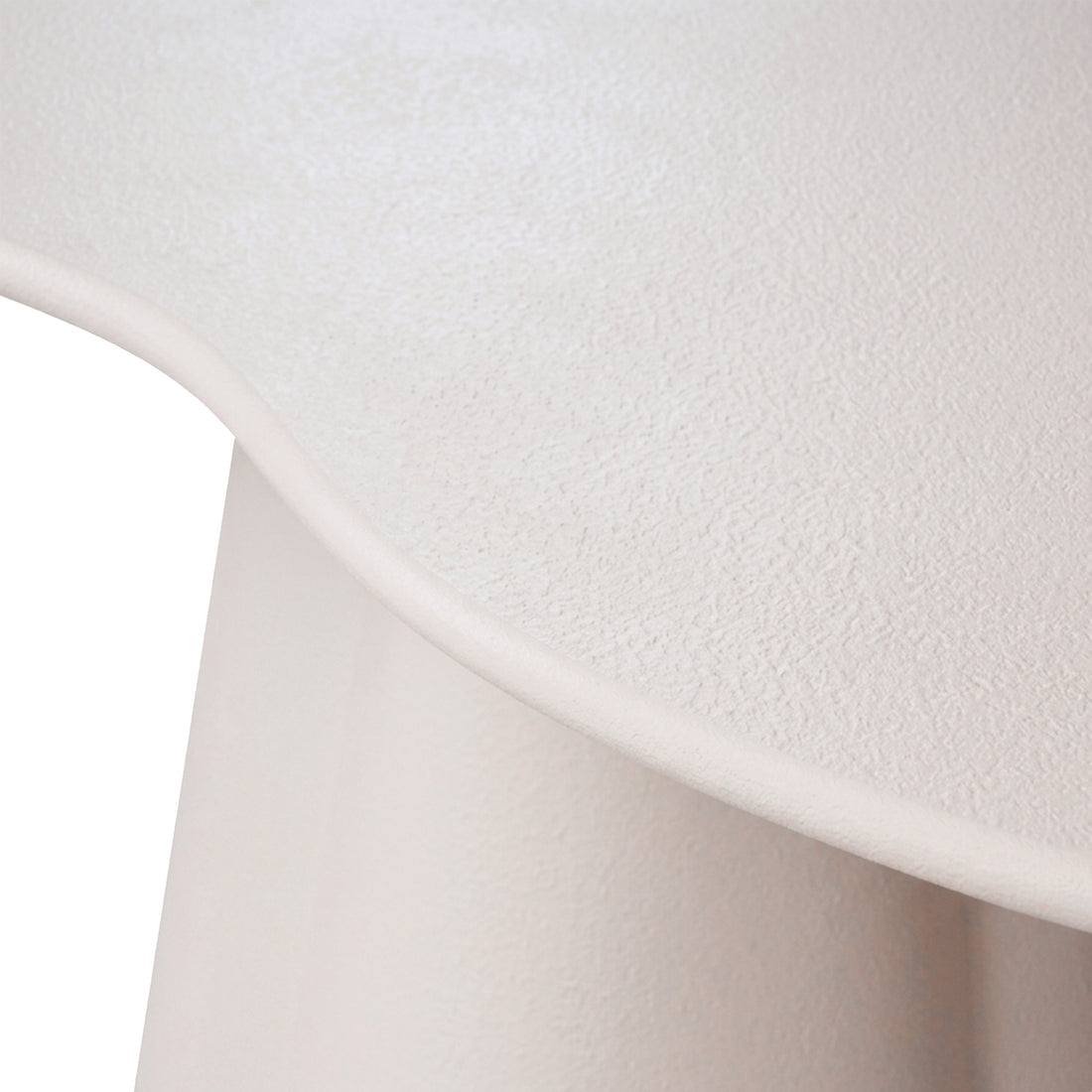 Close-up of a light-colored textured surface and curved furniture edge on a white background