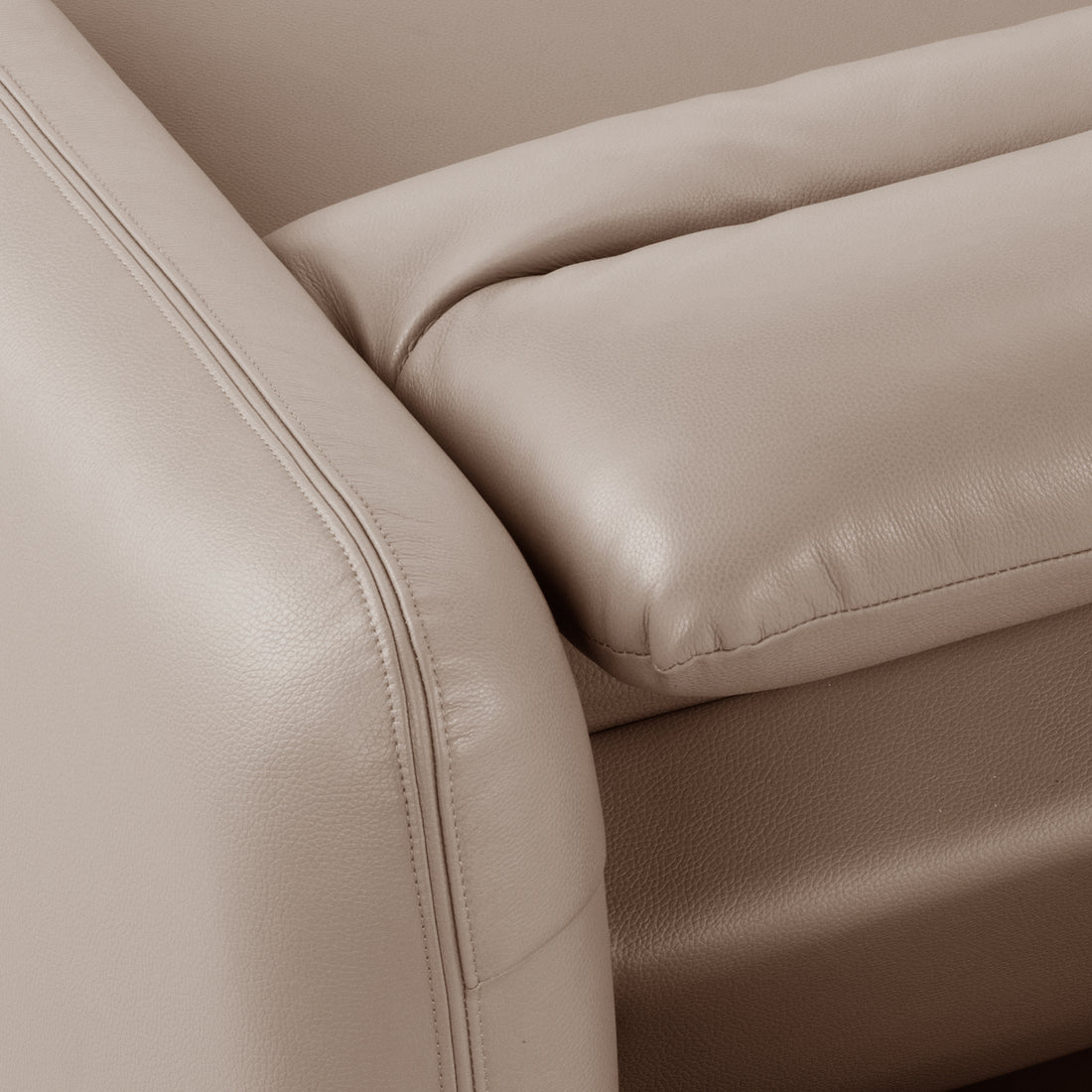 Close-up of beige leather sofa upholstery and stitching