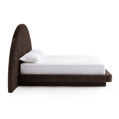 Side view of a modern upholstered bed with a rounded headboard on white background