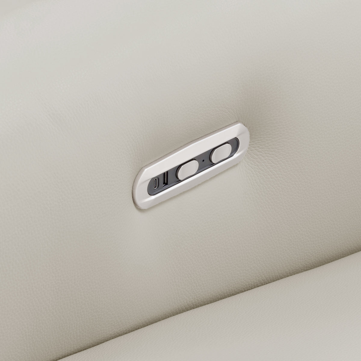 Close-up of a sofa control panel on light beige leather upholstery
