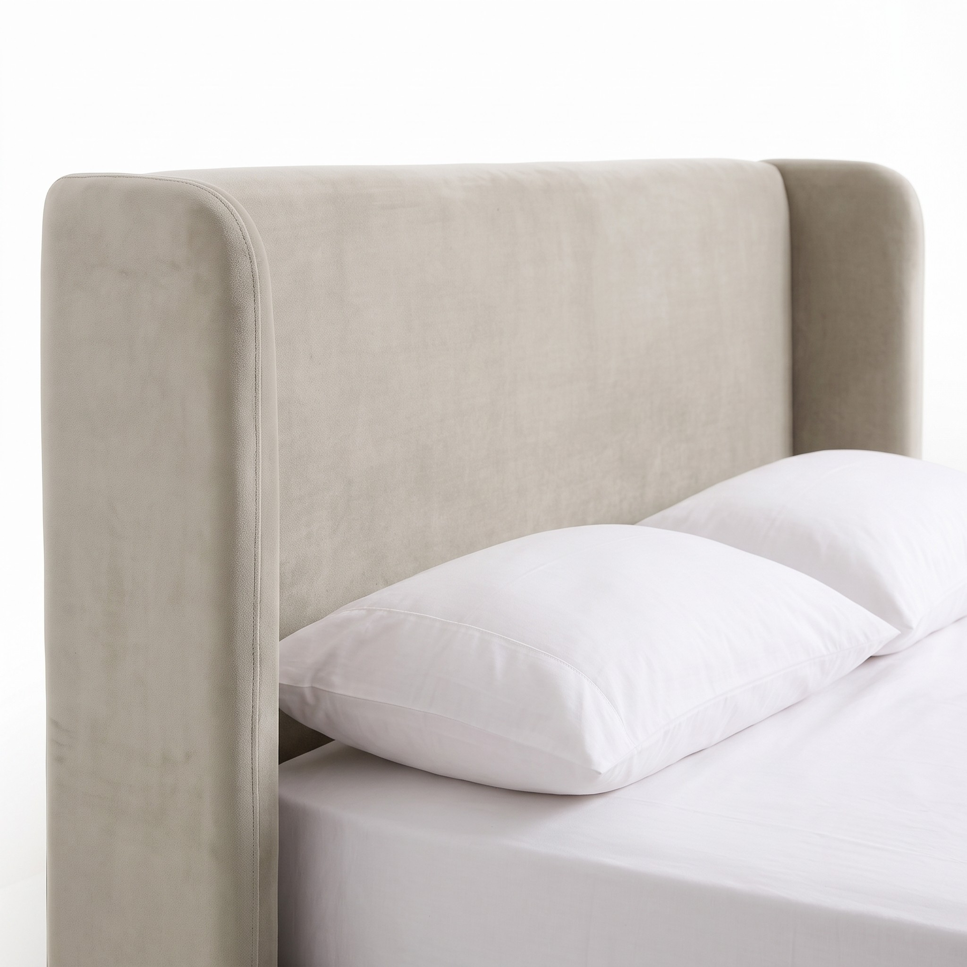 Close view of upholstered headboard and upper bed area on white background