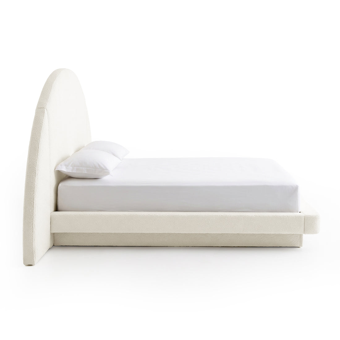 Side view of a modern upholstered bed with arched headboard on a white background