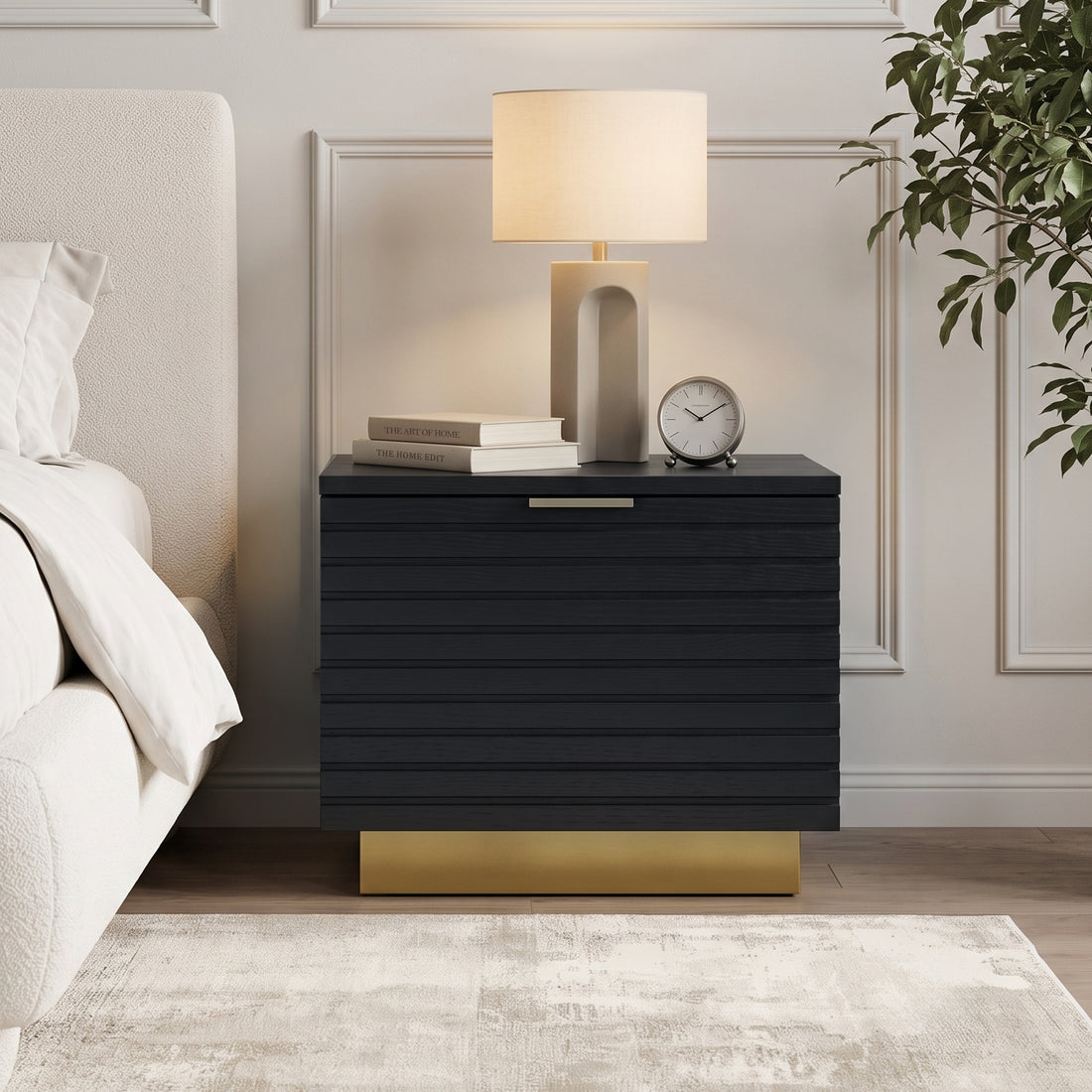 Black nightstand styled beside a bed in a modern bedroom