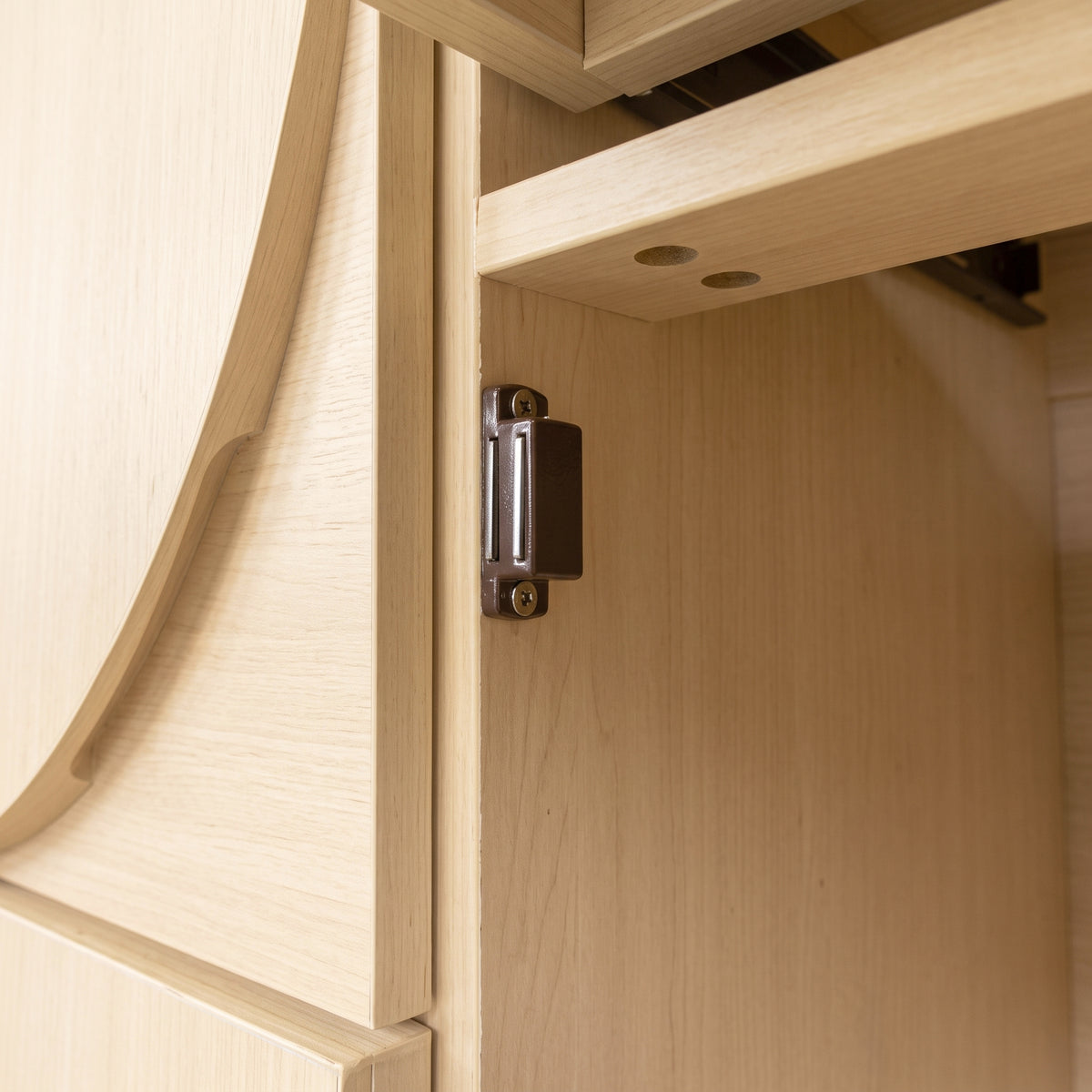 Close-up of a wooden cabinet hinge in a room setting