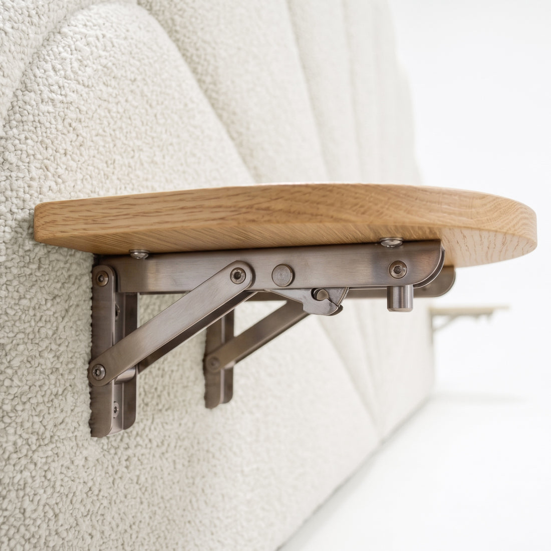Close-up of wooden shelf bracket mounted on upholstered surface