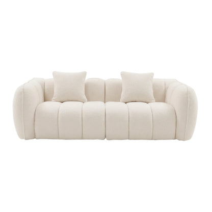 Contemporary cream-colored sofa with tufted upholstery and two cushions on white background