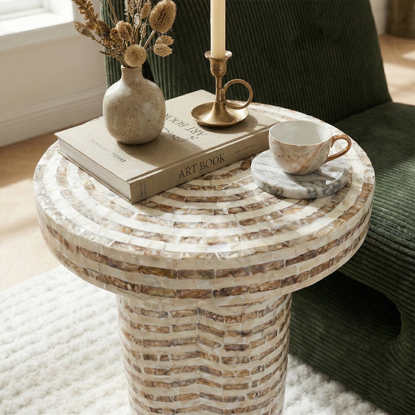 Round mosaic side table with vase and books in living space
