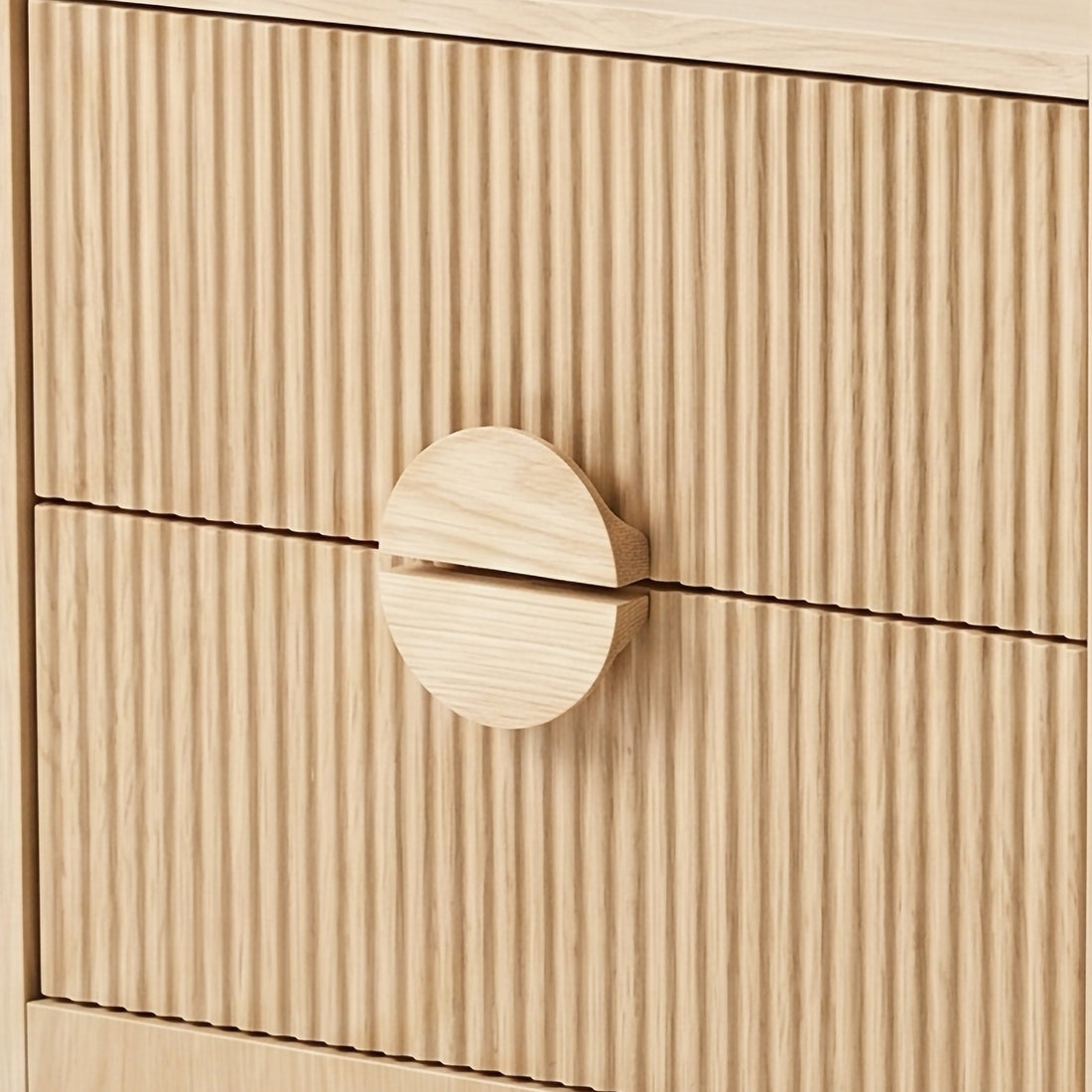 Close-up of ribbed wood drawer fronts with round wooden handle