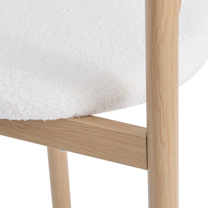 Close-up of a chair corner with textured white upholstery and light wood legs on a white background