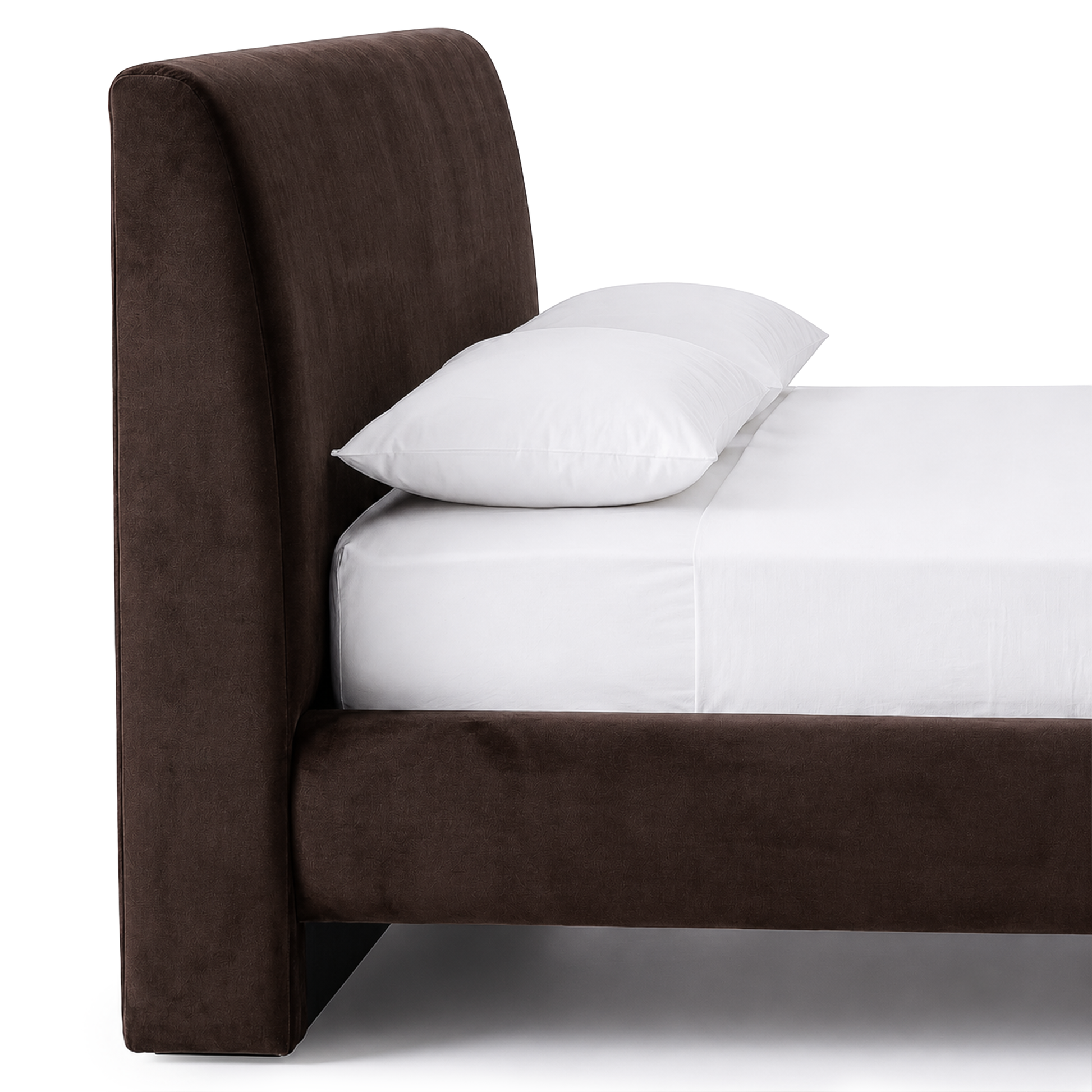 Partial view of an upholstered bed with headboard and bedding on white background