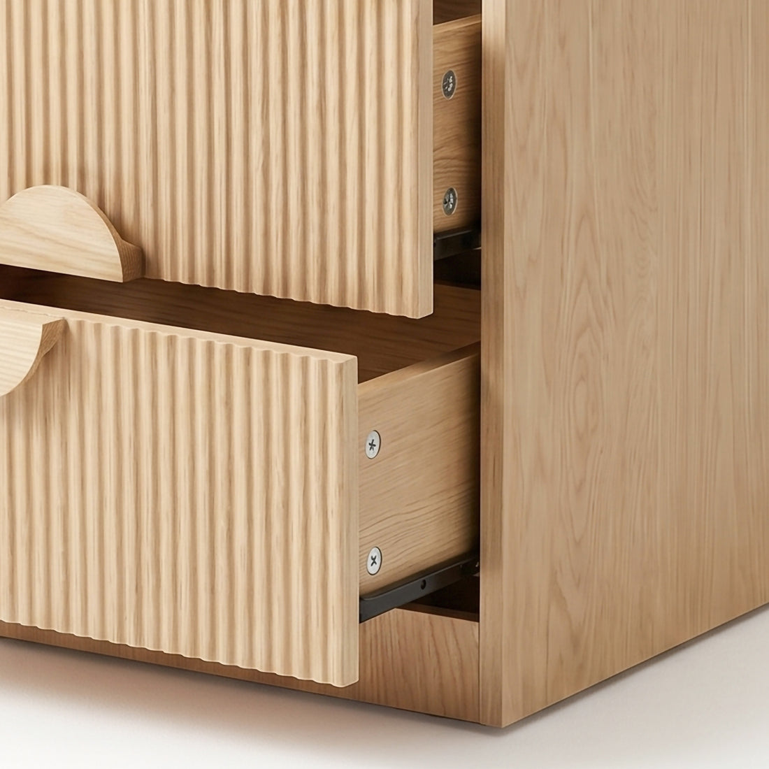 Close-up corner of light wood dresser with two ribbed drawers on white background