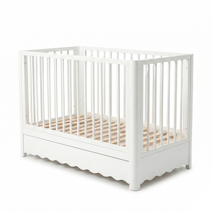 White baby crib on white background with vertical slats and minimalist design