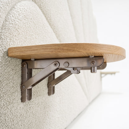 Close-up lifestyle view of wooden foldable shelf mounted on upholstered panel