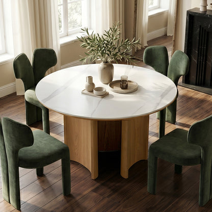 Round dining table with white top and green chairs in a stylish dining room