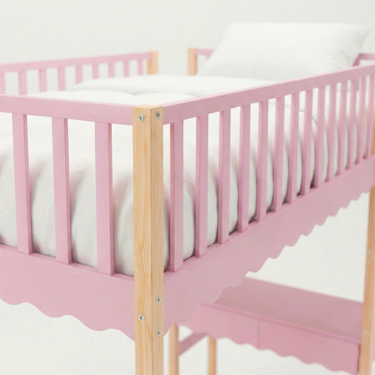 Close-up of pink frame and natural wood corner of children’s crib