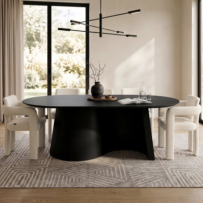 Modern black oval dining table styled in a bright contemporary dining room with chairs