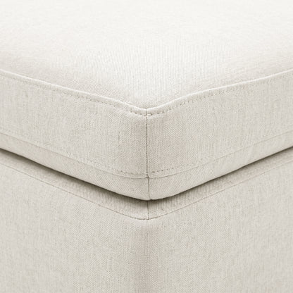 Close-up of cream upholstered cushion corner with stitching and textured fabric